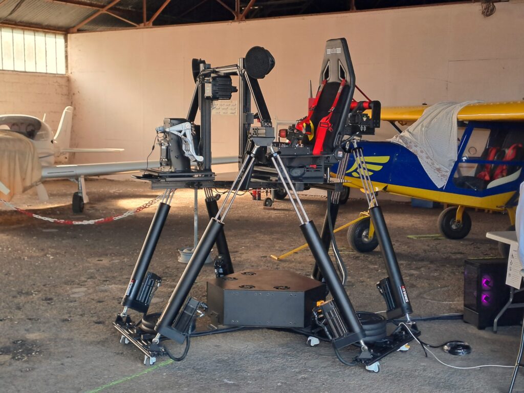 Simulateur dynamique posé dans un hangar avion à colmar en alsace grand est pour un événement journée porte ouverte aéroclub, pourpilote ou tout public